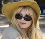 Julia de Nunez wears vintage style oval black sunglasses in the series Bardot (2023).