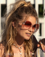 Abbey Lee wears a pair of pink butterfly sunglasses in Florida Man (2023).