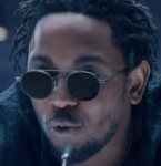 Kendrick Lamar wears a pair of round, grey Thom Browne sunglasses in the music video Bad Blood.