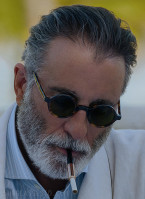 Andy Garcia wears small round sunglasses in the 2023 movie Pain Hustlers.