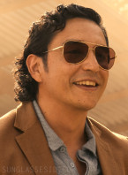 Gabriel Luna wears a pair of gold aviator sunglasses in the Netflix series FUBAR (2023).