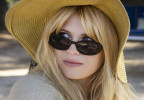 Julia de Nunez wears vintage style oval black sunglasses in the series Bardot (2023).