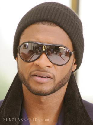 Usher is wearing a pair of black and gold Carrera Endurance sunglasses in the mu