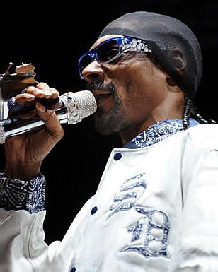 Snoop Dogg wearing blue Serious Pimp OG Bandana sunglasses during a concert