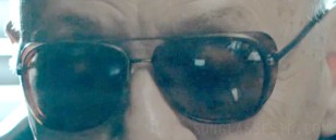 The glasses seem to have a dark metal frame and tortoise side shields