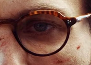 The glasses have a tortoise shell frame and three rivets on the front.