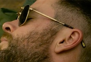 The glasses have a gold frame and gold logo at the arm tips
