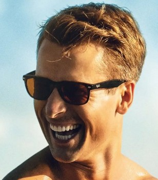 Glen Powell wears Ray-Ban RB2132 New Wayfarer sunglasses in Top Gun: Maverick.