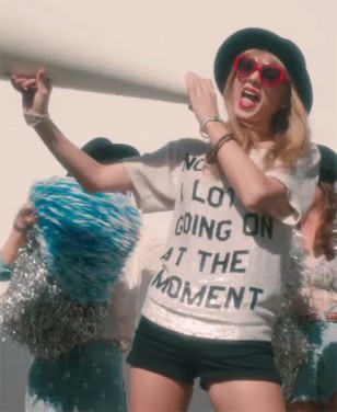 Taylor Swift wears red heart-shaped sunglasses and a "Not A Lot Going On At The Moment" top in the 22 music video.