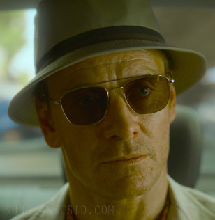 Michael Fassbender wears Police Origins Lite 2 SPL996 metal square aviator sunglasses in the 2023 movie The Killer.